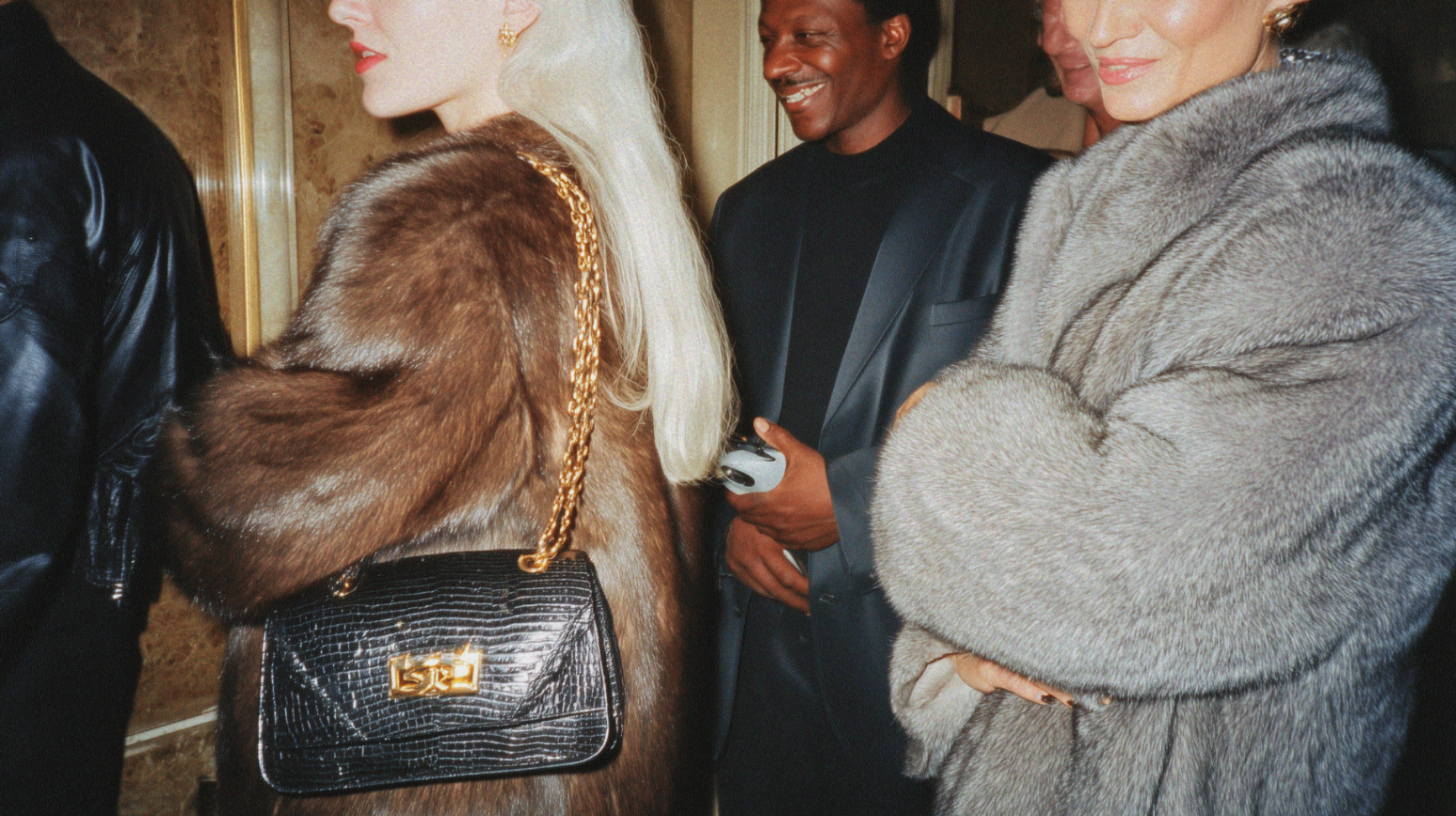 Guests in furs and tailored coats at an event
